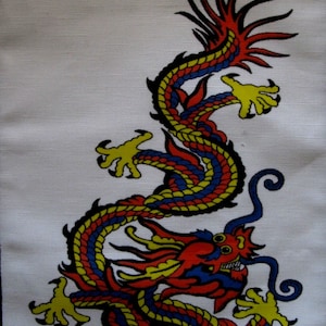 Puede incluir: Un dragón colorido con escamas rojas, amarillas y azules se representa sobre un fondo blanco. El dragón está enroscado en una posición defensiva con las garras extendidas.