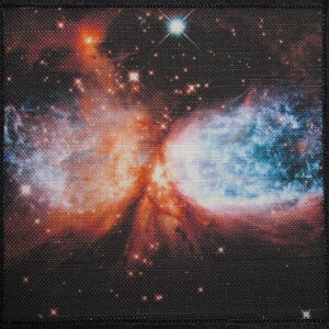 Puede incluir: Un primer plano de una nebulosa en el espacio con una estrella brillante en el centro. La nebulosa es una mezcla de colores rojo, naranja y azul. El fondo es azul oscuro con muchas estrellas.
