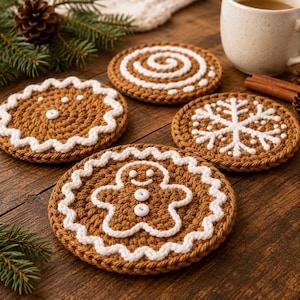 May include: Four round, brown crocheted coasters featuring white yarn embroidery. Designs include a gingerbread person with white buttons, a snowflake, a spiral, and a scalloped-edge cookie. Each coaster has a textured, thick yarn construction.