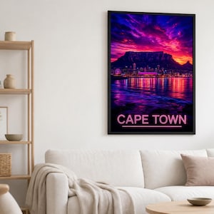 Peut inclure: Une impression d'art mural verticale encadrée représentant un coucher de soleil vibrant sur l'horizon de Cape Town et la Montagne de la Table, avec le texte CAPE TOWN en lettres néon rose en bas, aux dégradés de violet, magenta et orange.