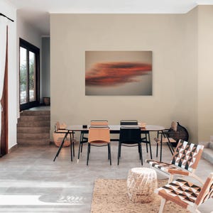 Könnte beinhalten: Ein modernes Esszimmer mit einem langen, dunklen Holztisch und sechs Stühlen. Die Stühle haben schwarze Metallrahmen und Ledersitze in Beige und Schwarz. Ein großes abstraktes Gemälde hängt an der Wand. Der Raum hat eine neutrale Farbpalette.