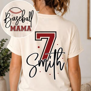 K&ouml;nnte beinhalten: Ein cremefarbenes T-Shirt mit einer gro&szlig;en kastanienbraunen Nummer 7 und dem Namen Smith in schwarzer Schreibschrift auf der R&uuml;ckseite. Ein kreisf&ouml;rmiger Einsatz zeigt den Text Baseball MAMA in Schwarz und Kastanienbraun mit einer Baseballgrafik.