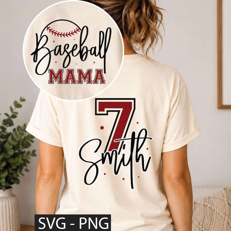 K&ouml;nnte beinhalten: Ein cremefarbenes Kurzarm-T-Shirt mit einer Grafik auf der R&uuml;ckseite, die die Zahl 7 in Dunkelrot, den Namen Smith in schwarzer Schreibschrift und kleine rote Punkte zeigt. Ein kreisf&ouml;rmiger Einsatz zeigt den Text Baseball MAMA mit einer Baseball-Grafik.