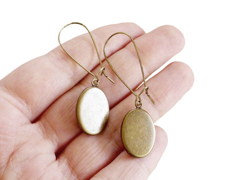May include: A pair of oval-shaped bronze earrings with a simple wire design.