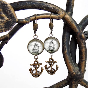 Op de afbeelding: Een paar bronzen oorbellen met een vintage scheepsafbeelding en een ankerbedel.