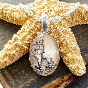 Op de afbeelding: Een zilveren ketting met een ronde hanger met een vintage illustratie van een duiker in een duikpak. De hanger is geplaatst in een transparante glazen koepel.