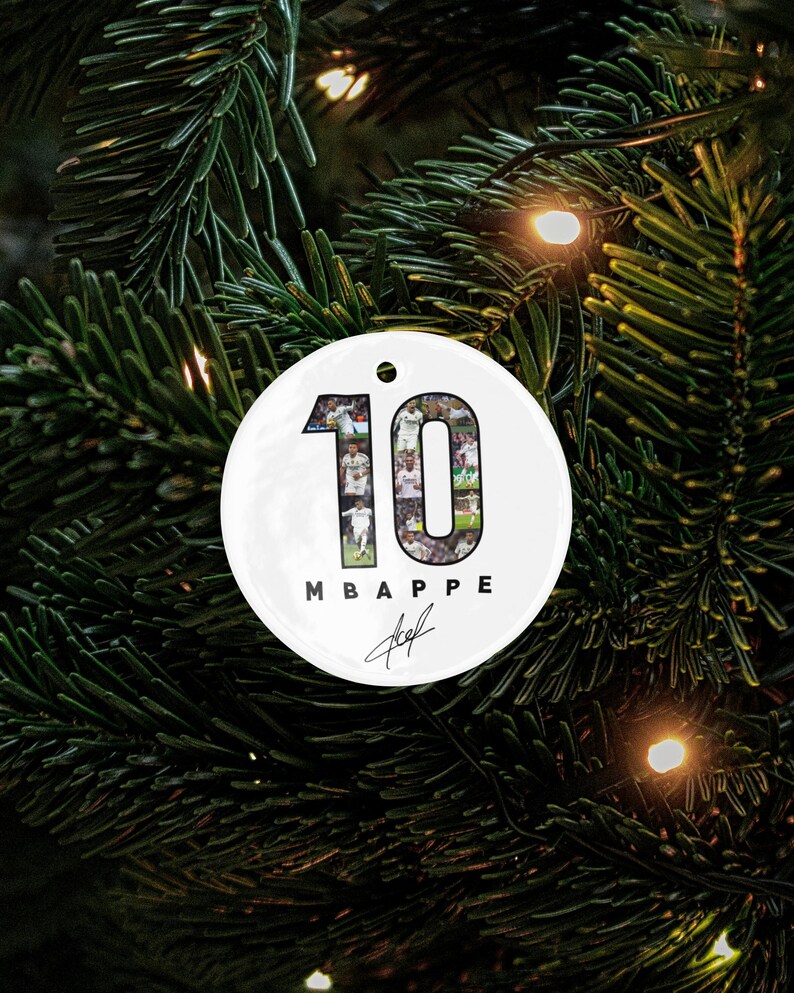A white ornament with the number 10 and the text "MBAPPÉ" is hanging on a Christmas tree.