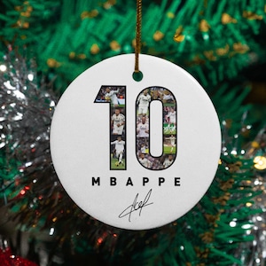 A white ornament with the number 10 and the text "MBAPPE" hanging on a Christmas tree.