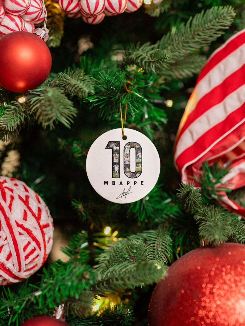 A Christmas tree decorated with ornaments, including a large red ornament, a white ornament with the number 10, and other ornaments in red and white.