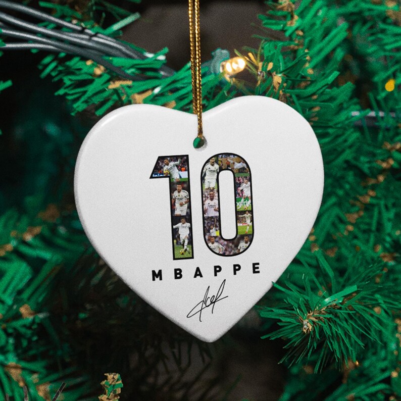 A heart-shaped ornament with the number 10 and the text "MBAPE" hanging on a Christmas tree.