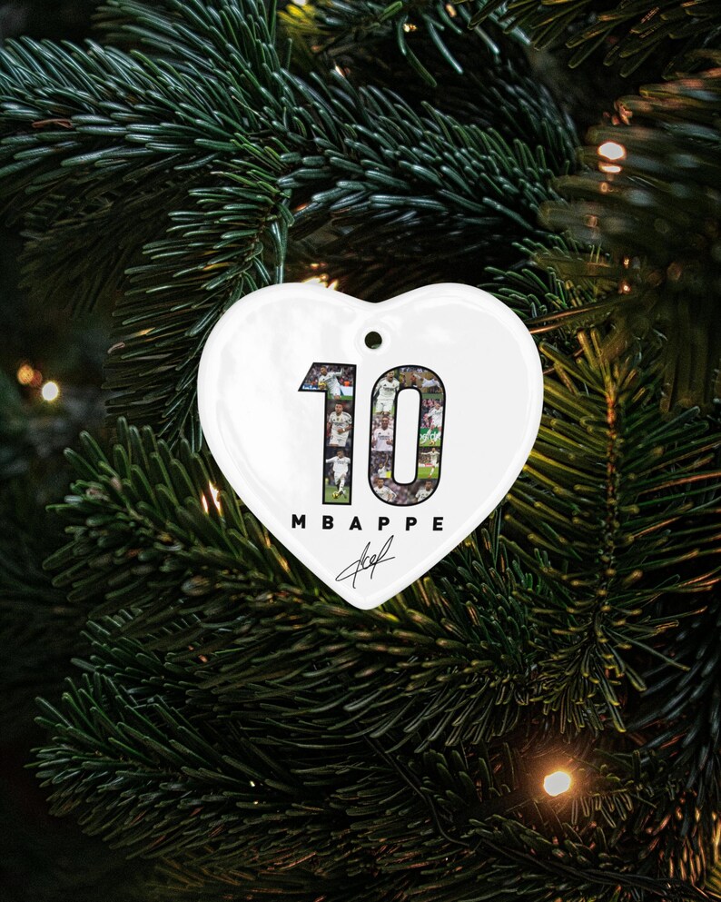 A heart-shaped ornament with the number 10 and the text "MBAPPÉ" is displayed on a Christmas tree.