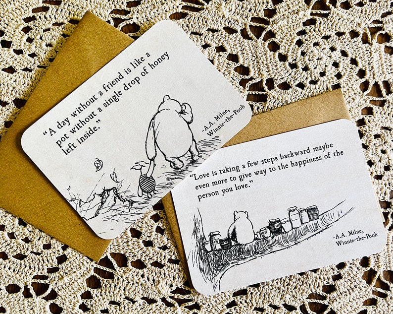 May include: Two Winnie-the-Pooh inspired cards with black and white illustrations and quotes. The first card says "A day without a friend is like a pot without a single drop of honey left inside." The second card says "Love is taking a few steps backward maybe even more to give way to the happiness of the person you love."