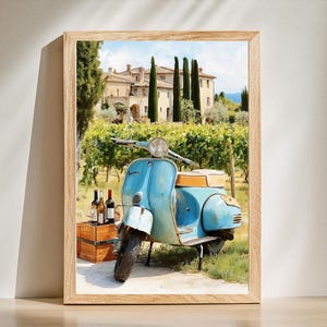 Könnte beinhalten: Gerahmter Kunstdruck mit einem blauen Vintage-Roller vor einem Weinberg und einer toskanischen Villa. Eine Holzkiste enthält Weinflaschen. Das Kunstwerk ist in einem hellen Holzrahmen.