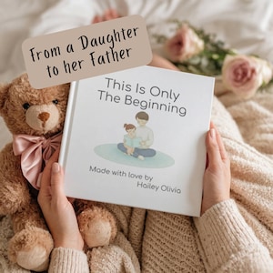May include: A white book titled "This Is Only The Beginning" with an illustration of a parent and child reading. The text "Made with love by Hailey Olivia" is also visible. A brown teddy bear with a pink bow is next to the book. The text "From a Daughter to her Father" is at the top.
