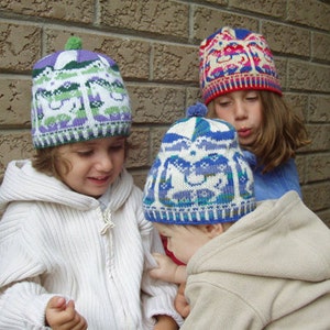 May include: Three children wearing colorful knitted hats with whimsical designs. The hats feature a white background with multi-colored patterns of animals and geometric shapes.