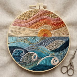 May include: A circular embroidery hoop containing a landscape scene of a sunset over the ocean. The sky features horizontal stitches in shades of pink, orange, and cream. The sea is depicted with textured blue and teal waves and foam.