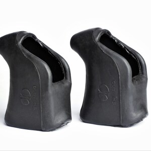 Puede incluir: Dos puños de manillar de bicicleta de goma negra. Cada puño tiene una forma curva con un área empotrada para la mano. El nombre de la marca "SHIMANO" está grabado en relieve en el lateral de cada puño. Los puños están diseñados para la comodidad y el control.