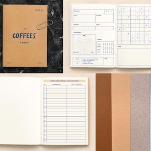 May include: A tan notebook with the text 22 COFFEES & SUDOKU on the cover. The interior pages feature blue printed templates for coffee tasting notes, a sudoku puzzle, and a numbered logbook for tracking twenty-two cafe visits.