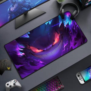 May include: A large rectangular gaming mousepad featuring a purple and blue illustration of a Gengar character with a wide grin and glowing red eyes. The design has a smoky, fiery effect. The mousepad is surrounded by gaming accessories.