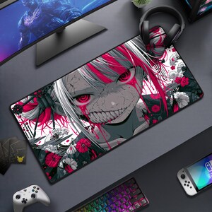 Puede incluir: Una alfombrilla de escritorio rectangular con una ilustración de estilo anime de alto contraste de un personaje con cabello blanco, reflejos rosa brillante y ojos rojos intensos. El personaje tiene una sonrisa amplia y está rodeado de motivos florales.