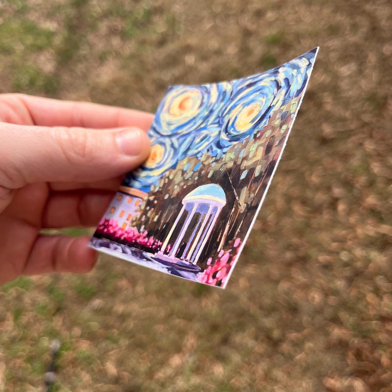 May include: A sticker featuring a painting of a white building with a blue roof and columns, surrounded by trees and a starry night sky. The painting is in the style of Vincent van Gogh's "Starry Night."