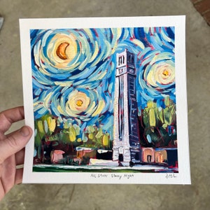 May include: A square print of a painting depicting a tall bell tower under a swirling night sky with a crescent moon. The artwork is in a style reminiscent of Van Gogh's "Starry Night." The text "NC State Starry Night" is at the bottom.
