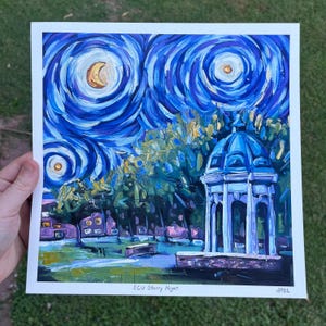 以下が含まれることがあります： 星空の夜空の下、青い屋根の白い東屋を描いた絵画。絵画はフィンセント・ファン・ゴッホの「星月夜」のスタイルです。絵画の下部には「ECU Starry Night」というテキストがあります。