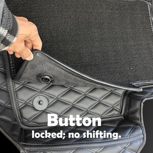Puede incluir: Alfombrillas negras para coche con un patr&oacute;n de diamantes acolchados. Las alfombrillas tienen un sistema de bloqueo con bot&oacute;n para evitar que se muevan. El texto "Button locked; no shifting" es visible.