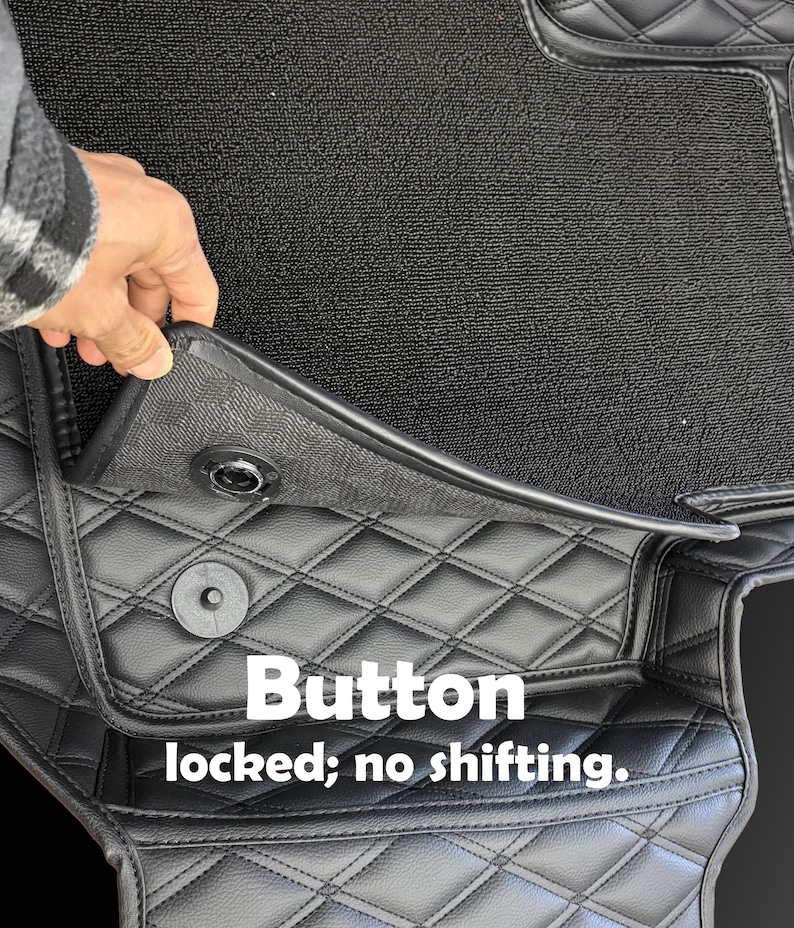 Puede incluir: Alfombrillas negras para coche con un patr&oacute;n de diamantes acolchados. Las alfombrillas tienen un sistema de bloqueo con bot&oacute;n para evitar que se muevan. El texto "Button locked; no shifting" es visible.
