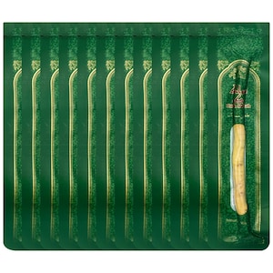 May include: A collection of green prayer mats with gold accents and vertical stripes. One mat has a natural miswak stick attached. The mats are packaged in a green plastic bag with Arabic text.