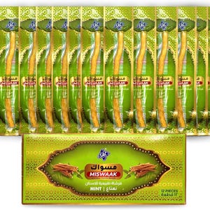 Könnte beinhalten: Eine Sammlung einzeln verpackter Miswaak-Naturzahnbürsten mit einer grünen und goldenen Schachtel am unteren Rand. Die Schachtel zeigt den Markennamen und Produktdetails in Englisch und Arabisch. Die Verpackung ist grün mit goldenen Akzenten.