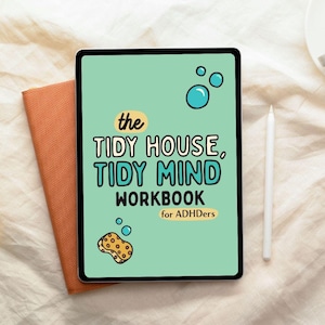 May include: A digital tablet with a mint green screen displaying "The Tidy House, Tidy Mind Workbook for ADHDers." The tablet is next to an orange notebook and a white stylus. The screen features bubble and sponge illustrations.