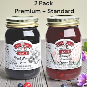 May include: Two glass jars of Das Haus jam, one black currant and one homestyle strawberry jalapeno. Each jar has a gold lid and a label with the brand name and product description. The text "2 Pack Premium + Standard" is at the top.