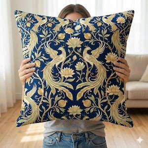 Könnte beinhalten: Dekoratives quadratisches Kissen mit dunkelblauem Hintergrund und einem sich wiederholenden Muster aus goldfarbenen Vögeln, Blumen und Blättern. Das Kissen hat ein klassisches, verziertes Design, das sich für die Heimdekoration eignet.