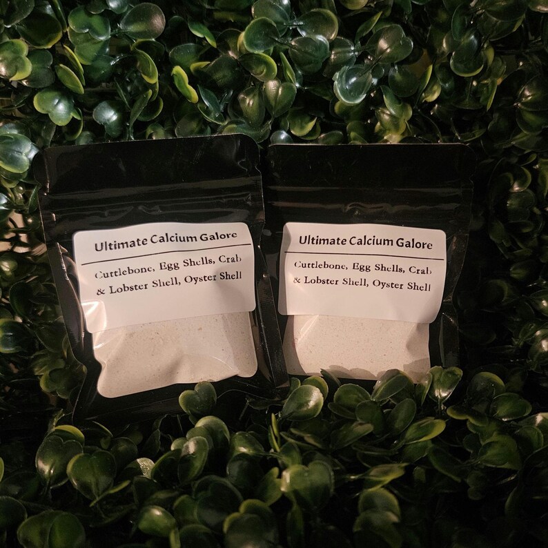 May include: Two black resealable pouches containing a white powder supplement labeled Ultimate Calcium Galore, with a list of ingredients including cuttlebone, egg shells, crab, lobster shell, and oyster shell printed on the white labels.