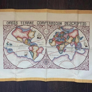 May include: A vintage embroidered map of the world, featuring the title "ORBIS TERRAE COMPENDIOSA DESCRIPTIO" and the date 1587. The map is in a circular design with continents in pastel colors, surrounded by a decorative border and a yellow border.