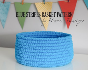 May include: A blue crocheted basket with a white background. The basket is made with a textured stitch and has a round shape. The text "BLUE STRIPES BASKET PATTERN by Henna's Boutique" is visible above the basket.