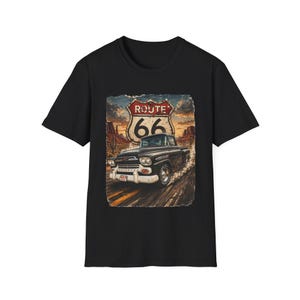 Puede incluir: Camiseta negra con un gráfico de la Ruta 66. El diseño muestra una camioneta negra vintage en una carretera, con el icónico letrero de la Ruta 66 en el fondo. El gráfico tiene un aspecto vintage.