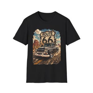 May include: Black t-shirt featuring a vintage Route 66 graphic. The design includes a classic car, the iconic Route 66 shield, and a desert landscape. The graphic is distressed, giving it a retro feel.