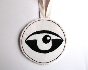 Textile wall hanging hand embroidered abstract eye on a round cream muslin long canvas loop