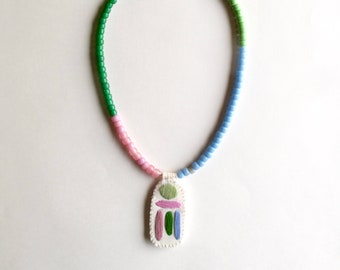 Hand embroidered necklace with abstract pendant and glass beads on silver leather cord with pink greens and blue colors An Astrid Endeavor