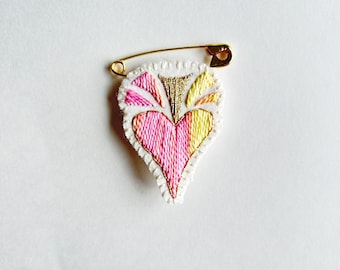 Embroidered heart brooch pink gold and yellow on bright cream muslin with cream felt back on gold tone safety pin Valentines Day gift guide