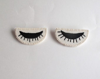 Eye brooch hand embroidered in black on cream muslin and cream felt winking eyes Spring fashion party favor listing is for ONE brooch