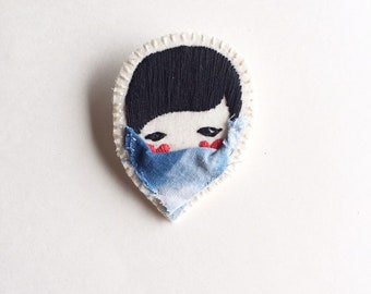 Embroidered jewelry brooch of face with red hearts black thread with blue shibori fabric face mask quarantine edition An Astrid Endeavor
