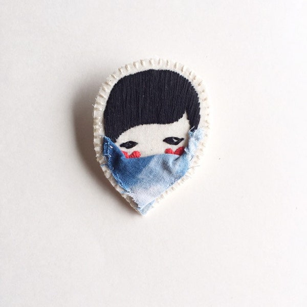 Embroidered jewelry brooch of face with red hearts black thread with blue shibori fabric face mask quarantine edition An Astrid Endeavor