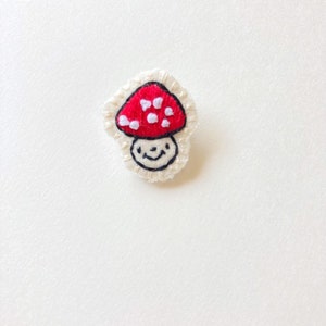 Hand embroidered mushroom brooch in red with white spots on cream muslin with felt backing Magic mushroom kawaii cute An Astrid Endeavor image 2