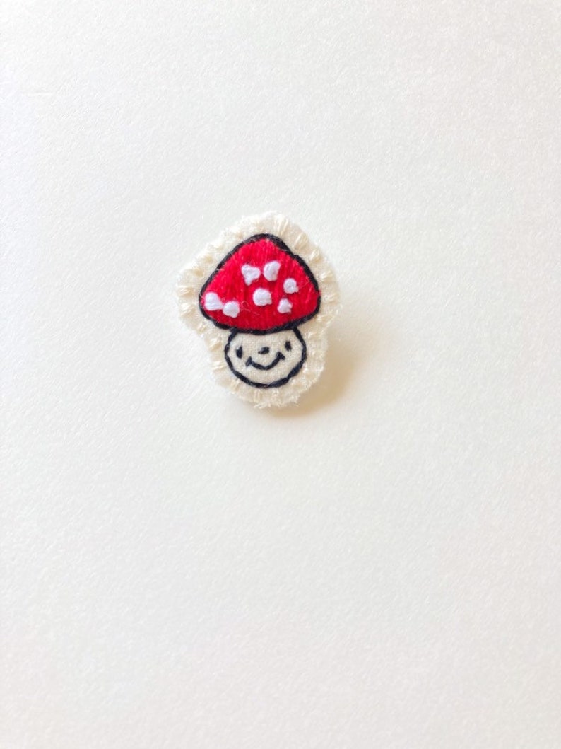 Hand embroidered mushroom brooch in red with white spots on cream muslin with felt backing Magic mushroom kawaii cute An Astrid Endeavor image 2