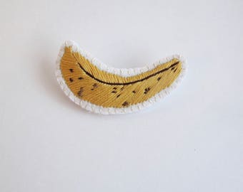 Embroidered banana brooch on cream muslin with cream felt backing yellow and brown cotton thread An Astrid Endeavor kitsch fashion