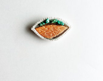 Hand embroidered brooch with unique abstract design using pale green tan and  peach thread with turquoise An Astrid Endeavor textile jewelry