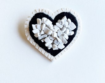 Hand embroidered heart brooch in black thread with Howlite gem beads stitched onto cream muslin with cream felt backing An Astrid Endeavor